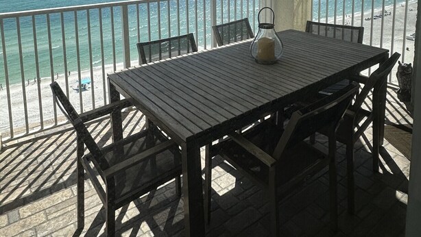 A balcony with a table and chairs overlooking a beach. - 3 Master Suites all with Gulf Front View! Free Golf Daily! (Panama City Beach)