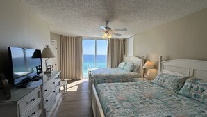 A hotel room with two beds, a TV, a desk, and a view of the ocean. - 3 Master Suites all with Gulf Front View! Free Golf Daily! (Panama City Beach)