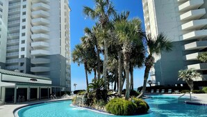 A swimming pool surrounded by palm trees and modern buildings. - 3 Master Suites all with Gulf Front View! Free Golf Daily! (Panama City Beach)