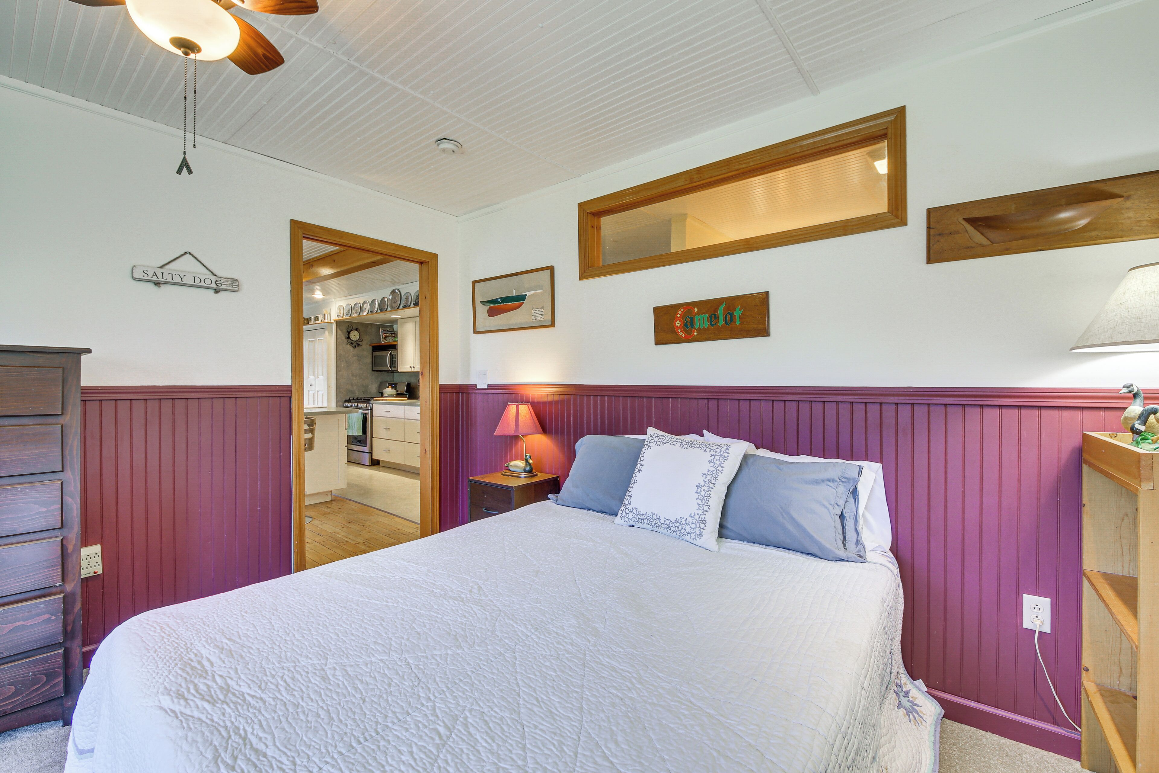 Ein Schlafzimmer mit einem Bett, einem Nachttisch, einer Lampe und einem Holzregal.