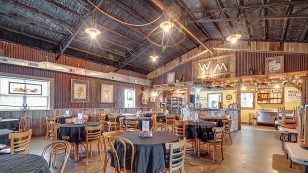 A restaurant with wooden tables and chairs, a bar area, and a menu board. - Spacious Owensville Getaway w/ Winery On-site! (Rosebud)