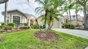 A residential area with a house featuring a driveway, a lawn, and a palm tree. - Near Golf & Wdw: Family-friendly Home in Davenport (Davenport)