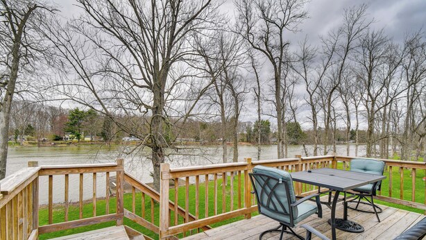 A wooden deck with a table and chairs, overlooking a body of water and trees. - Riverfront Baldwinsville Apartment w/ Shared Deck! (Baldwinsville)