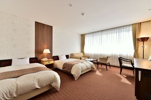 A hotel room with two beds, a desk, a chair, a lamp, and a window with curtains. - KKR Kyoto Kuniso (Kyoto)