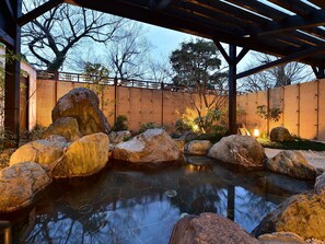 A tranquil garden with a pond, large rocks, and bamboo plants. - KKR Kyoto Kuniso (Kyoto)