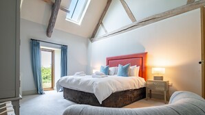 Une chambre à coucher avec un grand lit, une table de chevet, une fenêtre et une porte.