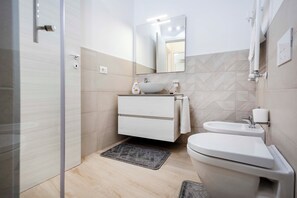 Chuveiro, secador de cabelo, bidê, toalhas de banho