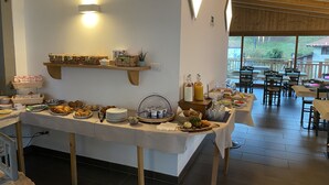 A buffet setup with various food items and a seating area with tables and chairs.