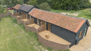 A two-story building with a tiled roof and a gravel driveway.