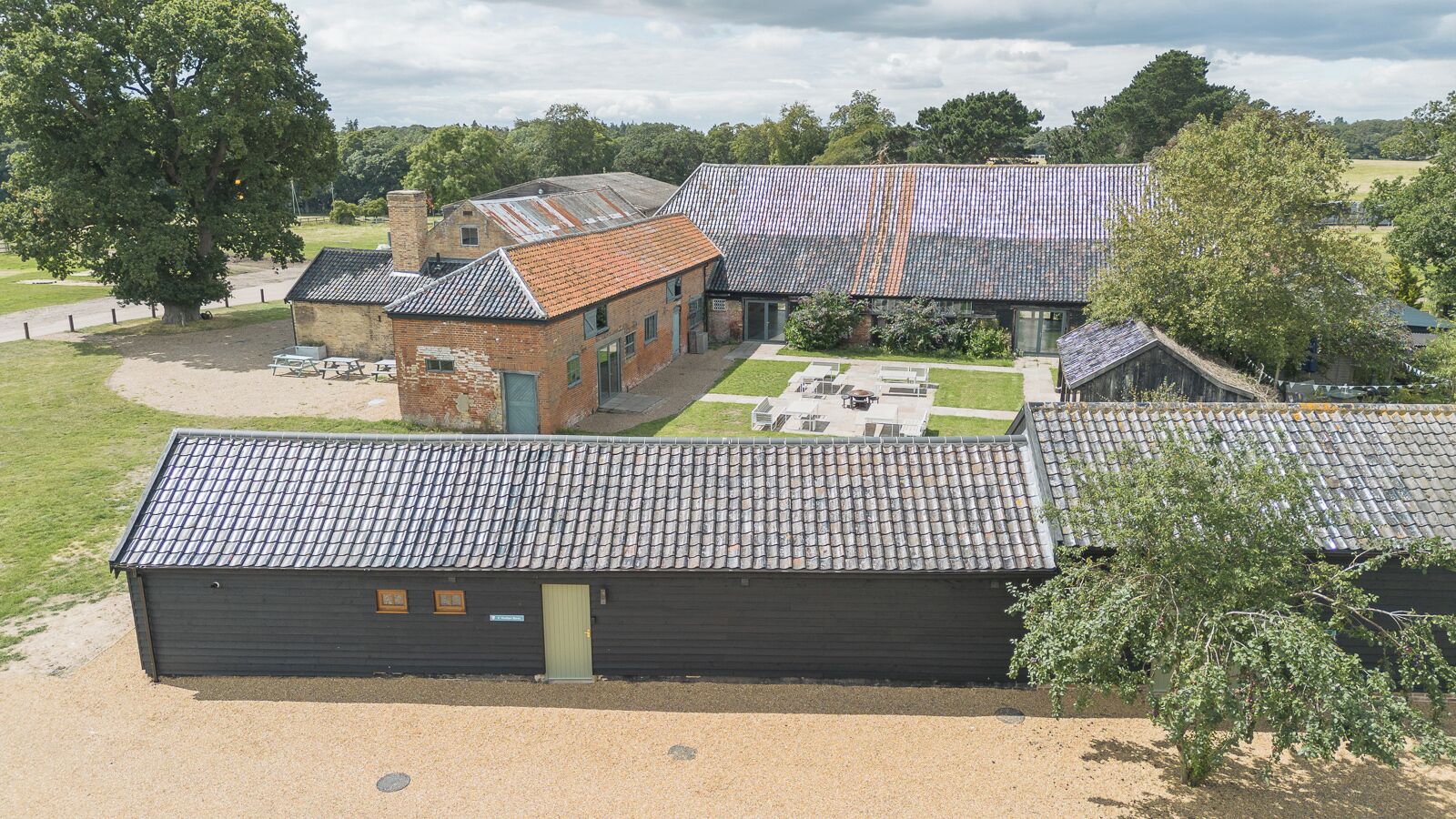 A building with a tiled roof, a brick structure, and a paved courtyard.