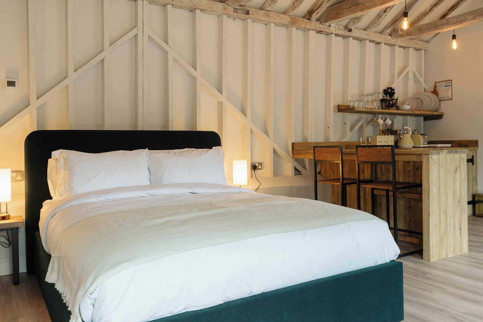 A bedroom with a large bed, a wooden desk, and a chair.