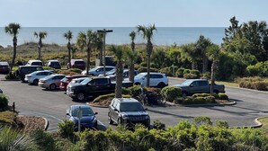 Ein Parkplatz mit verschiedenen Autos und Blick auf das Meer.