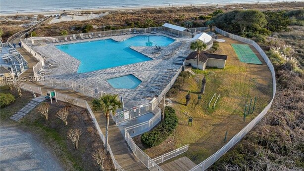 Ein Resort mit zwei Schwimmbecken, einem Tennisplatz und Blick auf den Strand.