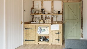 A compact kitchen with wooden cabinets, a built-in oven, and a sink. - 4 Henham Barns, Henham Park nr Southwold, NR34 8AQ, Carefully restored Character filled barn (Beccles)