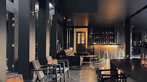 A modern interior with a bar area, seating, and a staircase.