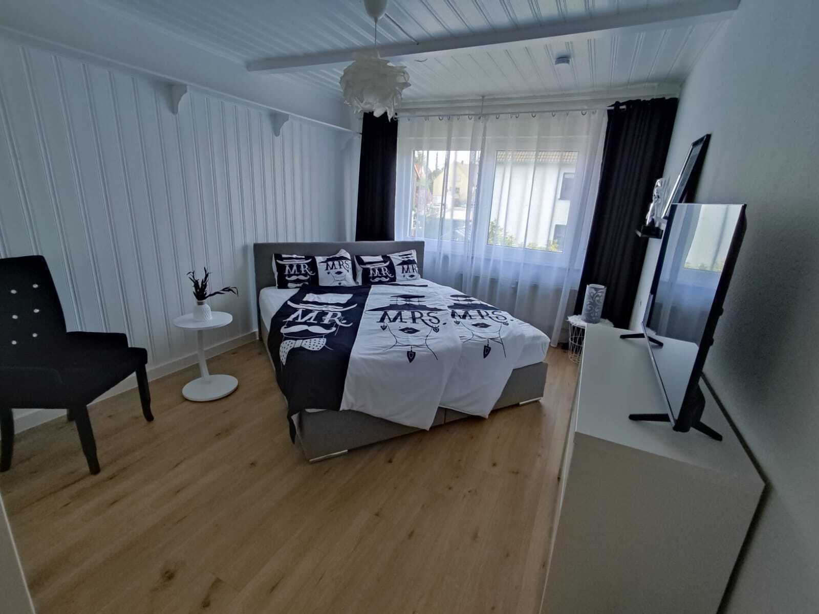 Una camera da letto con un letto, una sedia, un tavolino e una televisione.