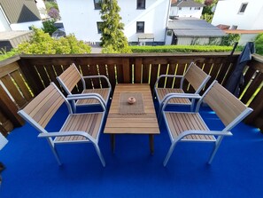 A wooden deck with a blue floor, surrounded by a wooden fence. - Family-friendly apartment to feel good with flair and a large balcony  (Langenzenn)