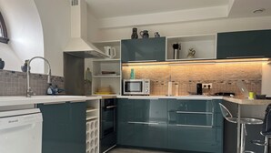 Una cocina moderna con microondas integrado, cafetera y lavaplatos.