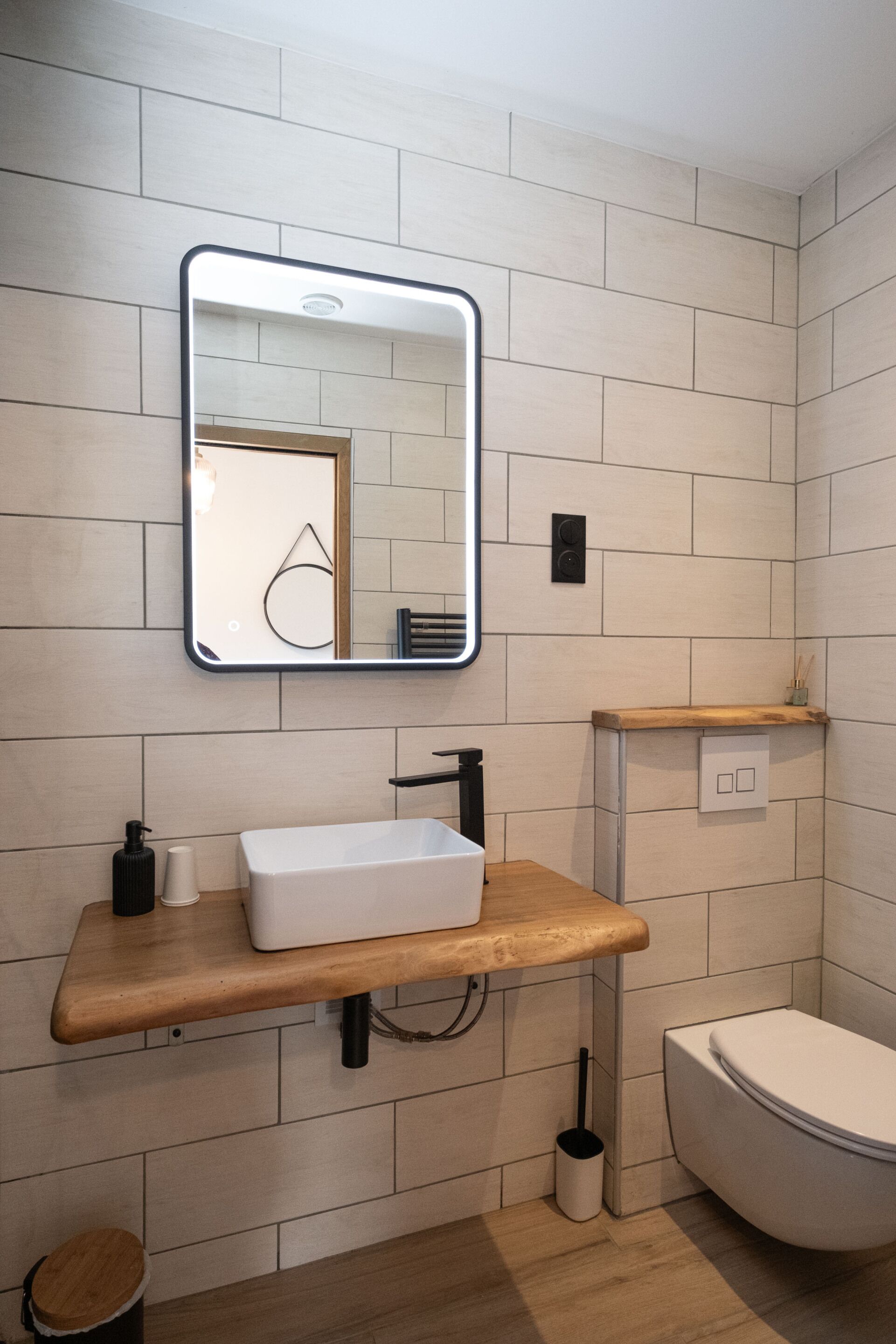 Une salle de bain moderne avec un lavabo blanc, un miroir et des toilettes.