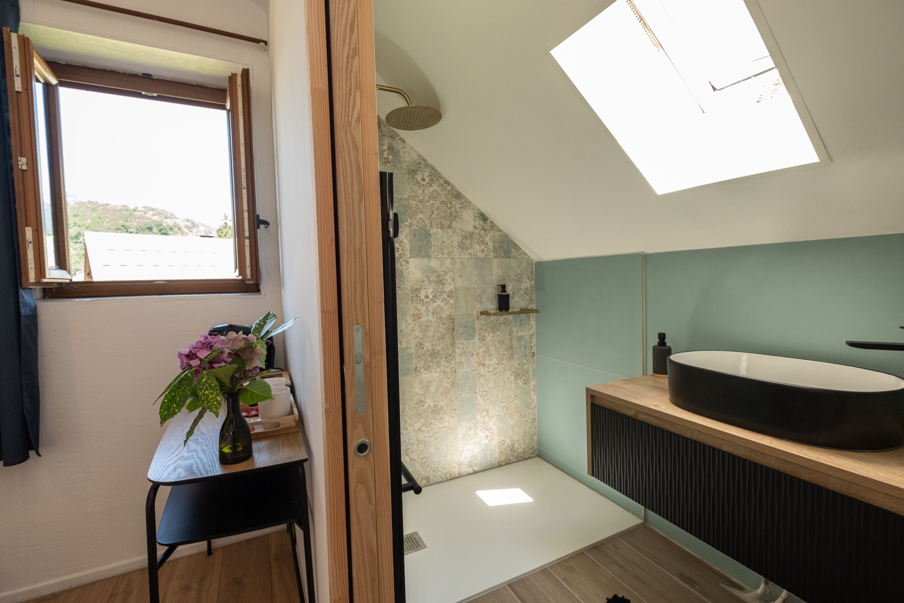 Une salle de bain moderne dotée d’un puits de lumière, d’une grande baignoire et d’un meuble-lavabo en bois.