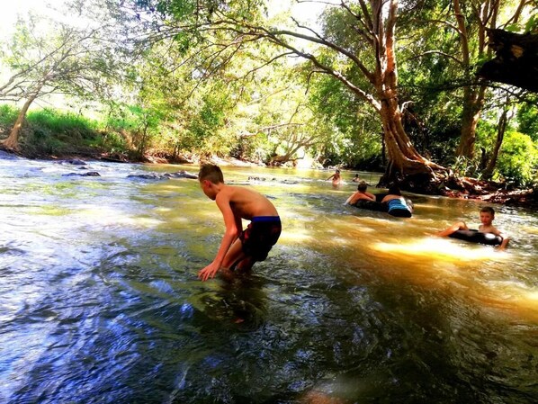 Un río con gente en el agua, rodeado de árboles.