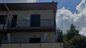 Un edificio con balcón y cielo despejado con nubes.