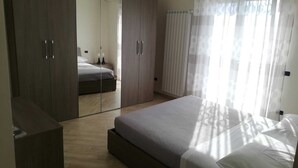 Un dormitorio con una cama grande, un armario y un closet con espejo.
