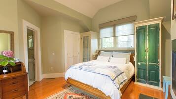 Quarto com cama, penteadeira e porta verde.