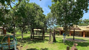 A playground with swings, a slide, and climbing structures. - Pousada Portal do Manso (Cuiabá)