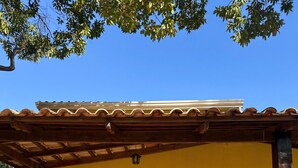 A yellow building with a wooden pergola, a hammock, and a fire extinguisher. - Pousada Portal do Manso (Cuiabá)