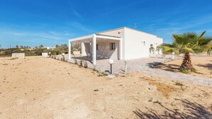 A modern white building with a covered patio area, a palm tree, and a clear blue sky. - 3863 Dimora Le Frasche - Trilo 1 by Barbarhouse (Porto Cesareo)