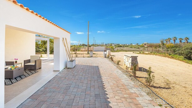 A patio area with outdoor furniture, a pathway leading to a building, and a view of the surrounding landscape. - 3863 Dimora Le Frasche - Trilo 1 by Barbarhouse (Porto Cesareo)