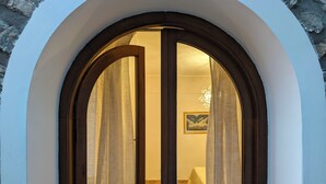 A doorway with an arched design, wooden frame, and two curtains. - Perfect destination for families and friends, nestled between seas and mountains (Praiano)