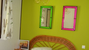 A bed with white bedding, a wicker headboard, and a green wall with two mirrors. - Haut de Chalet Le Bois de Cerf , Animaux Acceptés en Lisière de Foret (Les Angles)