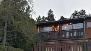 A two-story building with a balcony, a garage, and a stone wall. - Haut de Chalet Le Bois de Cerf , Animaux Acceptés en Lisière de Foret (Les Angles)