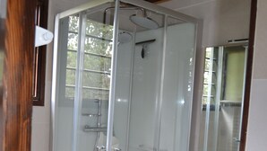 A glass-enclosed shower stall with a white sink and mirror above it. - Haut de Chalet Le Bois de Cerf , Animaux Acceptés en Lisière de Foret (Les Angles)