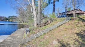 Un escalier en bois menant à une maison située au bord d’un lac.