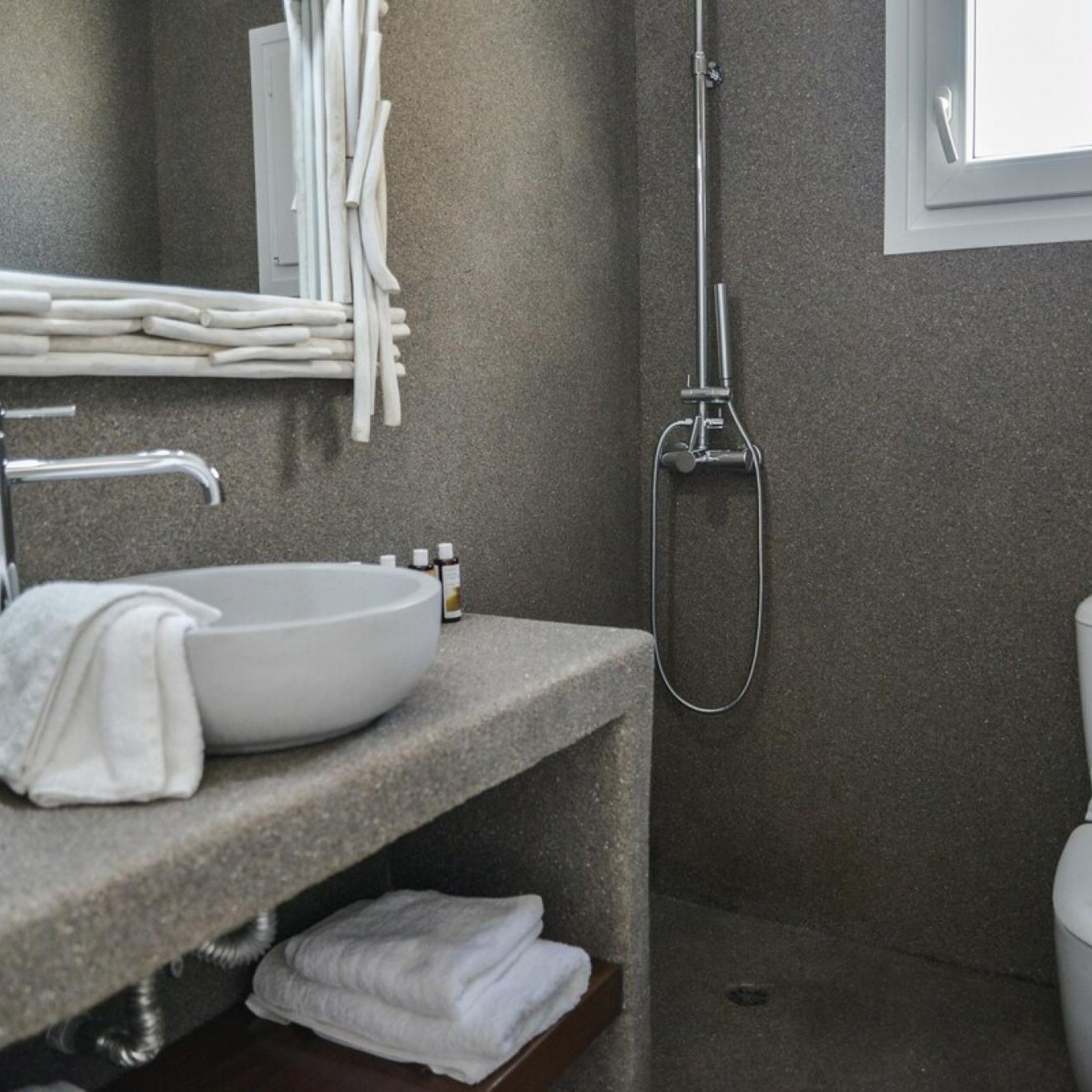 Un bagno moderno con un lavandino bianco, un porta asciugamani e una doccia.