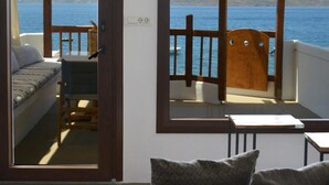 Una habitación con vistas al mar, una terraza de madera y una cama con vista.