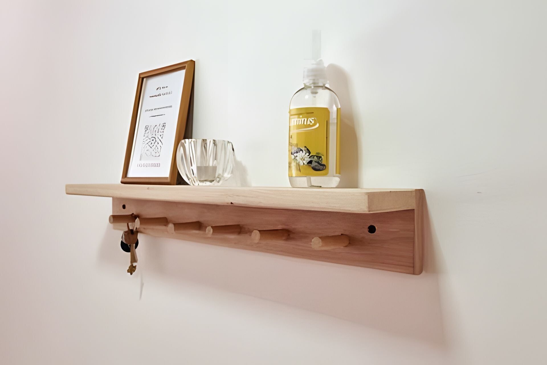 Uno scaffale di legno con un certificato incorniciato, un bicchiere e una bottiglia di gel disinfettante.