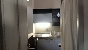 A narrow kitchen with a sink, cabinets, and a window. - Palace of Alboin (Pavia)