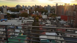 A cityscape with various buildings and a sunset in the background. - Hornera Lagos - Modern, Spacious & Bright (Rosario)