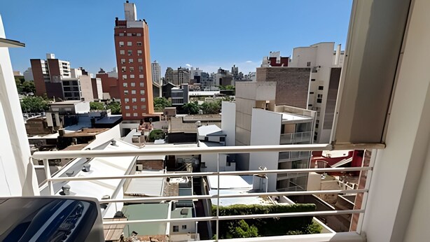 A high-rise building with multiple balconies and a view of the surrounding urban landscape. - Hornera San Juan - Bright Balcony Apartment (Rosario)