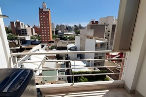 A high-rise building with multiple balconies and a view of the surrounding urban landscape.