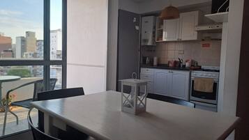 A modern kitchen with white cabinets, a gas stove, and a small island with a lantern.