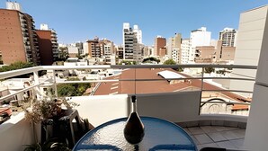 A balcony with a view of a cityscape, including buildings and a clear sky. - Hornera San Juan - Bright Balcony Apartment (Rosario)