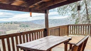 A wooden deck with a table and benches overlooking a scenic landscape. - Overlook the river @ Wildwood (Max Meadows)