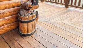A wooden cabin with a log exterior, a wooden deck, and a bear sculpture on the deck. - Overlook the river @ Wildwood (Max Meadows)