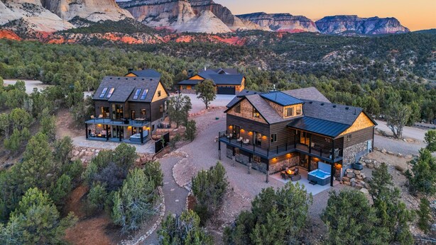 Un complexe hôtelier moderne doté de plusieurs chalets, chacun offrant de grandes fenêtres et des espaces de détente en plein air.