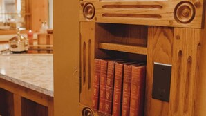 Eine Holzkommode mit integriertem Bücherregal, das mehrere rote Bücher enthält.